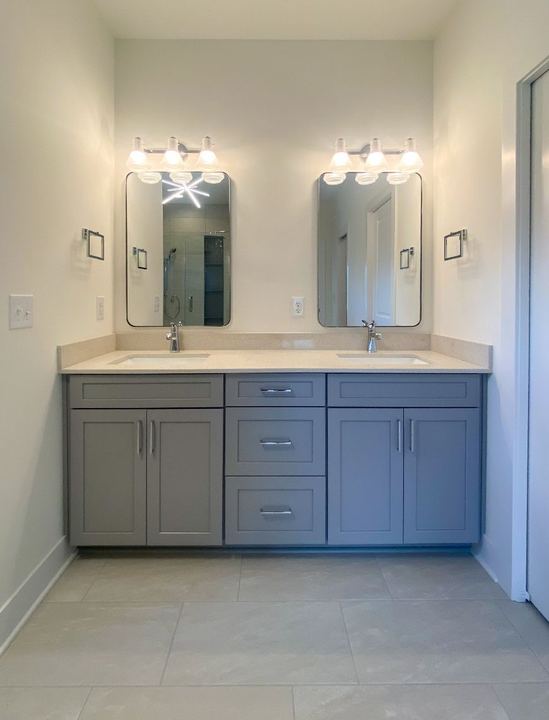 Master bathroom with 24x24 gray porcelain tile floor, double gray vanity and quartz countertop in Avon, IN