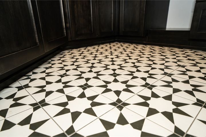 Black and white star-pattern ceramic tile floor beside dark shaker cabinetry in Plainfield, IN
