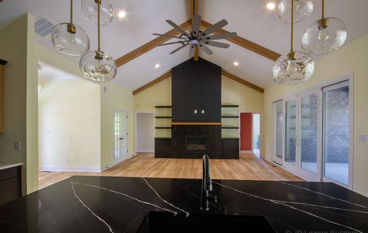 Vaulted great room with black tile fireplace surround and wood-look plank flooring in Avon, IN