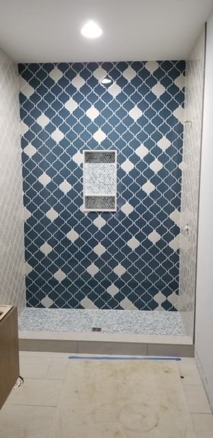 Tiled shower with blue and white arabesque accent wall, penny tile niche and mosaic shower pan in Plainfield, IN