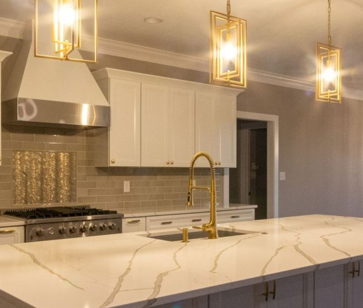 Kitchen with taupe subway backsplash, metallic herringbone accent and brushed gold faucet in Avon, IN