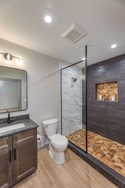 Full bath with charcoal large-format tile shower, amber hex mosaic pan and niche, and wood-look floor in Westfield, IN