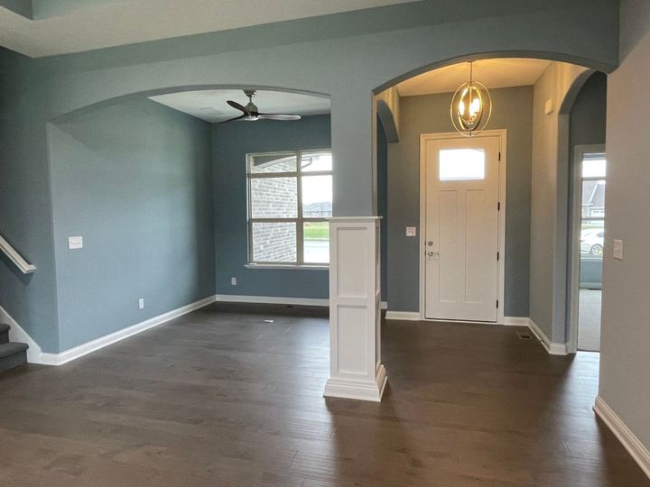 Dark stained maple hardwood flooring through an entry and dining room with blue-gray walls in Plainfield, IN