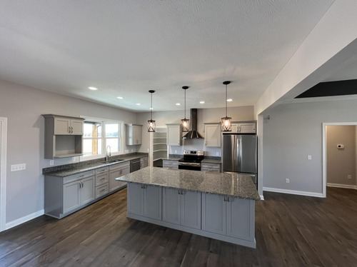 Dark hardwood plank flooring in a remodeled kitchen with gray cabinets and granite island in Danville, IN