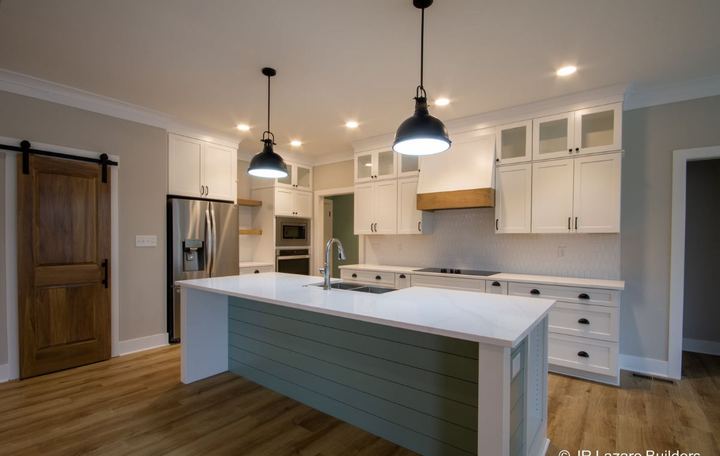 Farmhouse kitchen with white hex tile backsplash, sage shiplap island and wood-look plank flooring in Avon, IN