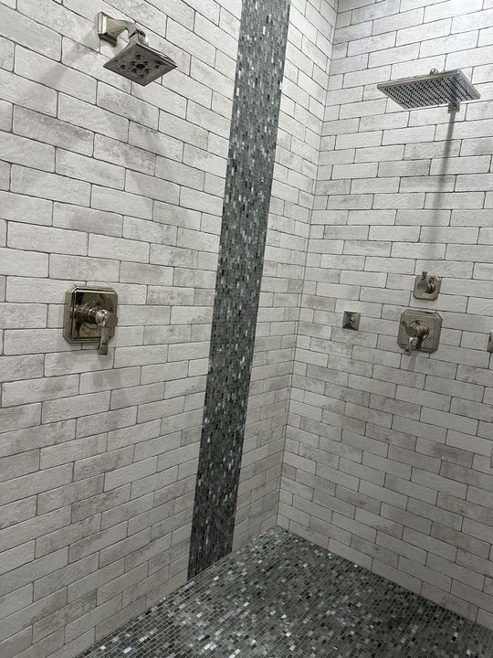 Dual-head master shower with white brick-look tile and glass mosaic accent band in Avon, IN