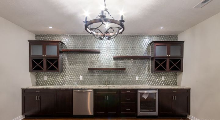 Basement wet bar with full-height glass triangle mosaic backsplash, dark cabinets and hardwood floor in Avon, IN
