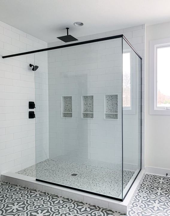 White subway tile walk-in shower with marble mosaic pan and gray patterned bathroom floor tile in Avon, IN