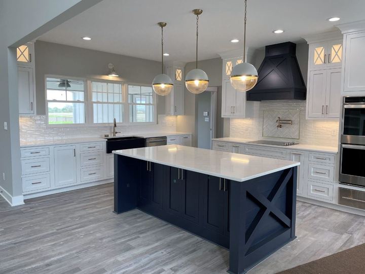 White glazed subway backsplash with gold-framed herringbone accent over the range and gray LVP floors in Plainfield, IN
