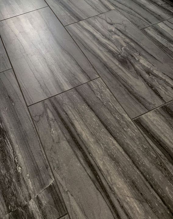 Closeup of gray marble-striated plank tile flooring in a master bathroom in Avon, IN