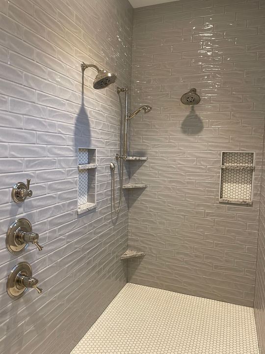 Walk-in shower with gray subway tile, hex mosaic niches, granite corner shelves and white penny-round floor in Plainfield, IN