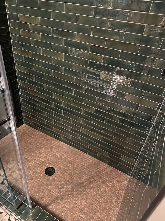 Walk-in shower with glossy green subway tile walls and tan penny-round mosaic floor in Avon, IN