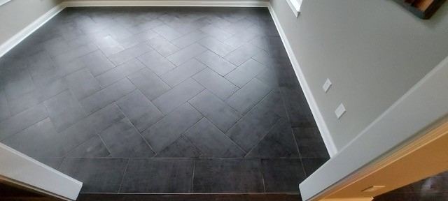 Charcoal plank tile entry floor with a herringbone center inlay bordered by straight-lay tile in Danville, IN