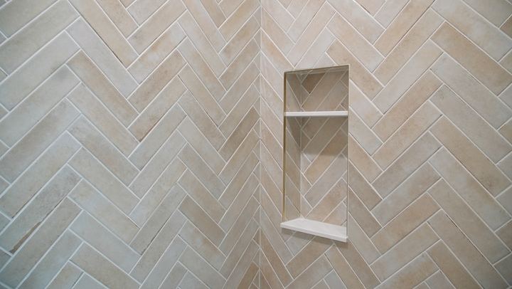 Shower wall in herringbone-set tile with recessed niche and shelf detail in Greencastle, IN