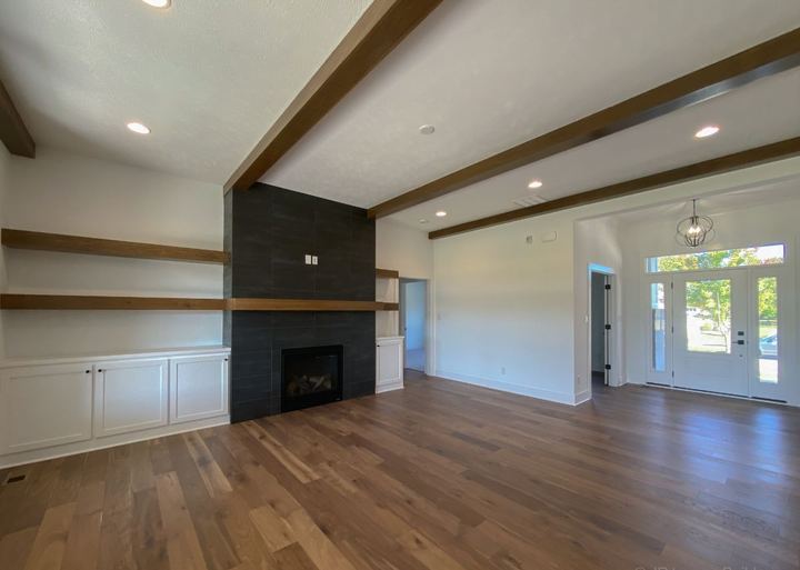 Great room with wide hickory hardwood flooring and floor-to-ceiling black tile fireplace surround in Avon, IN