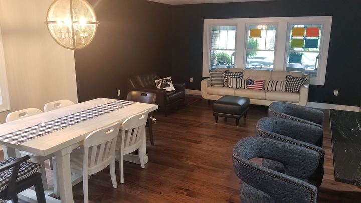 Hand-scraped hickory hardwood flooring in an open living and dining area with a dark accent wall in Avon, IN