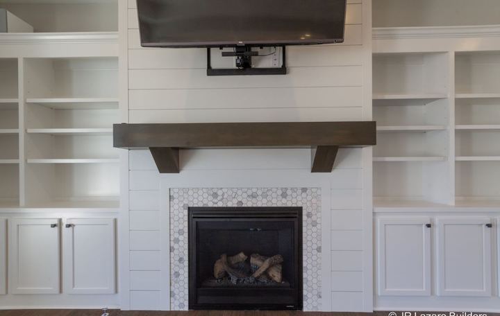 Marble hexagon tile fireplace surround with shiplap accent wall and rustic wood mantel in Avon, IN