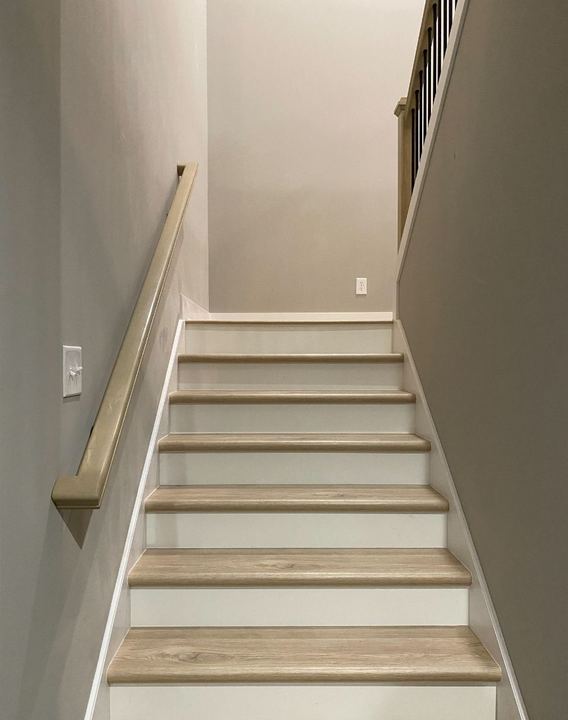 Staircase with light oak wood treads, white risers and matching oak handrail in Avon, IN