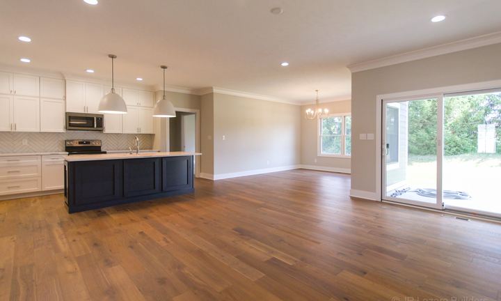 Wide-plank hardwood flooring through an open-concept kitchen and dining area with navy island in Avon, IN