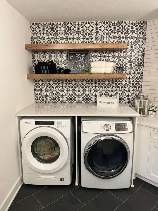 Laundry room with black and white patterned tile accent wall and dark slate-look tile floor in Pittsboro, IN