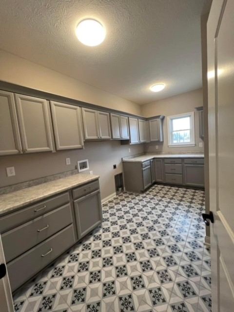 Gray and white patterned tile floor in a large laundry room with gray cabinetry in Brownsburg, IN