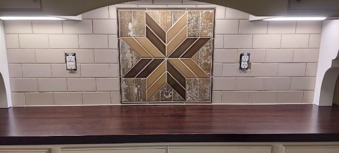 Beige subway backsplash with wood-look quilt-star mosaic accent over a dark walnut hutch counter in Avon, IN