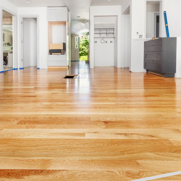 Freshly finished light red oak hardwood flooring running through an open hallway and entry in Danville, IN