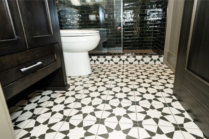 Black and white star-pattern porcelain tile bathroom floor with dark green subway shower and espresso cabinet in Brownsburg, IN