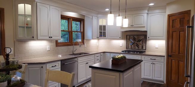 Remodeled kitchen with white subway tile backsplash and decorative wood-look mosaic accent above the cooktop in Avon, IN