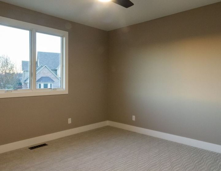 Bedroom with beige wave-textured patterned carpet and taupe walls in Avon, IN
