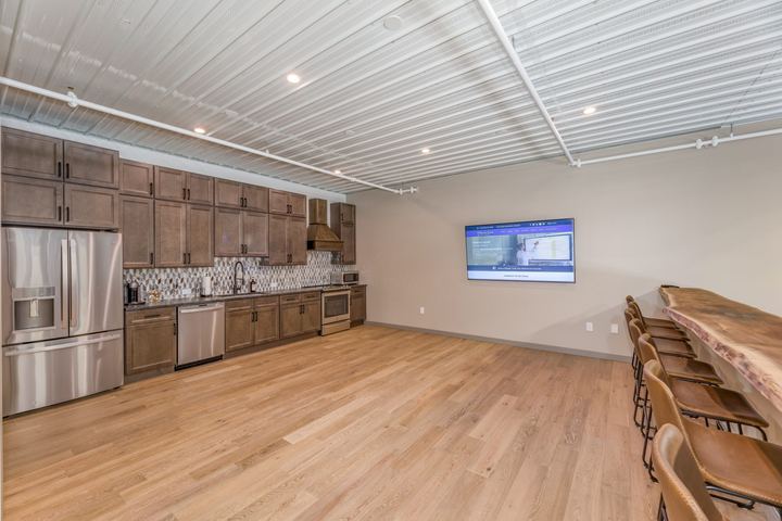 Light white oak hardwood flooring in a garage condo kitchenette with live-edge bar and mosaic backsplash in Westfield, IN