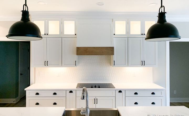 White farmhouse kitchen with elongated picket mosaic tile backsplash and black pendant lights in Avon, IN