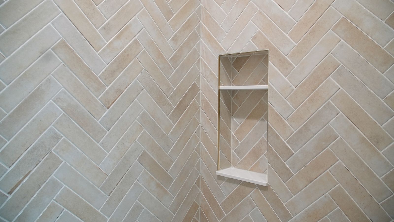 Shower wall in herringbone-set tile with recessed niche and shelf detail in Greencastle, IN